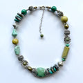 Necklace with green and silver beads on a white background