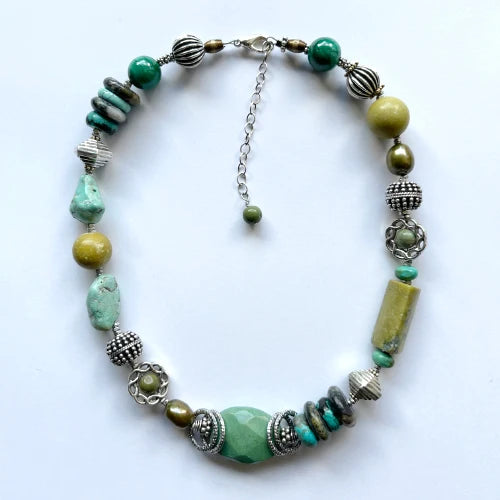 Necklace with green and silver beads on a white background