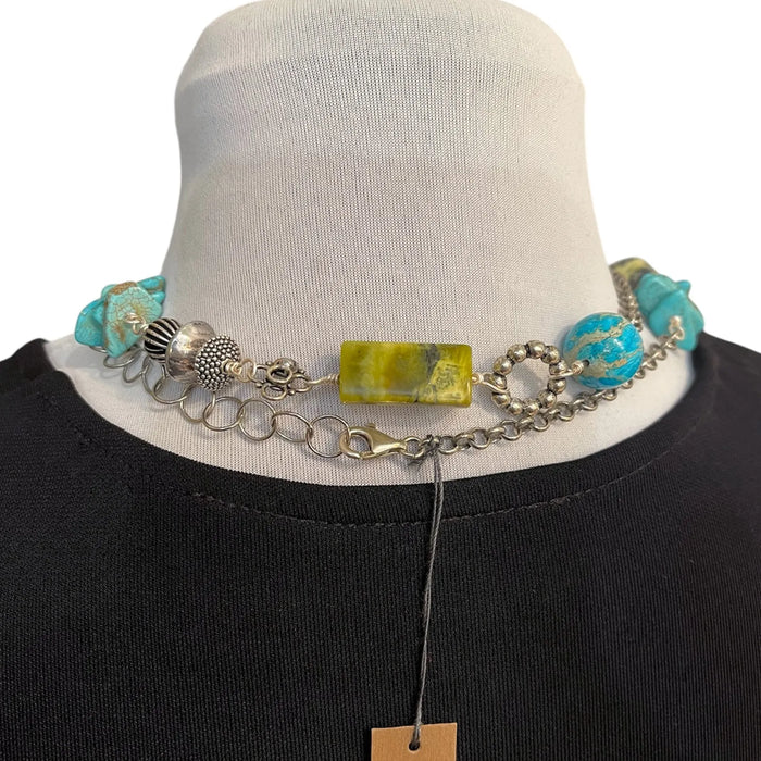 Necklace with turquoise and yellow beads on a mannequin against a white background