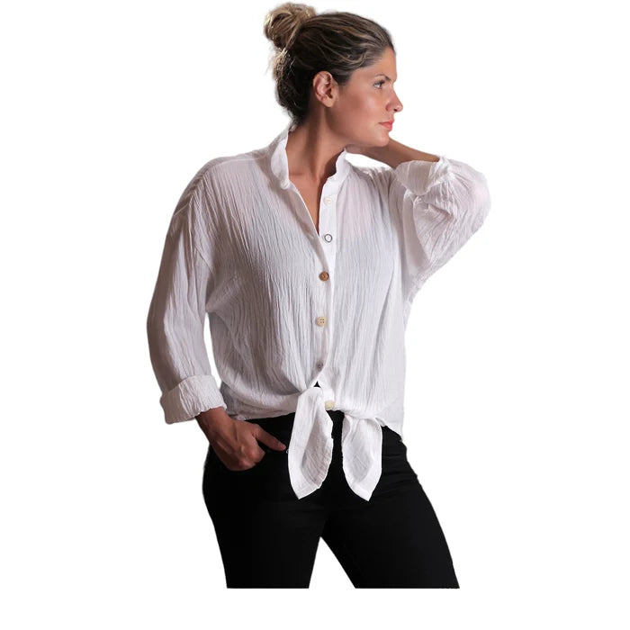 Woman wearing a white button-up shirt with rolled-up sleeves on a white background