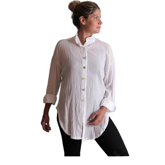 Woman wearing a white button-up shirt with rolled-up sleeves on a white background